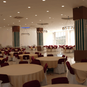 Alanya düğün salonu Güney, 500 kişilik kapasitesi, yuvarlak masa düzeni, minderli sandalyeleri, bahçede yemek servisi ve açık otoparkıyla öne çıkar.